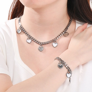 Gros plan d'un ensemble de collier et bracelet cubains argentés avec pendentifs cœurs