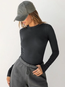Close-up of black ribbed crew neck long sleeve top showing slim fit texture on model