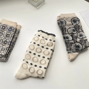 Detail of vintage floral and circle pattern socks with ruffle cuffs in neutral tones