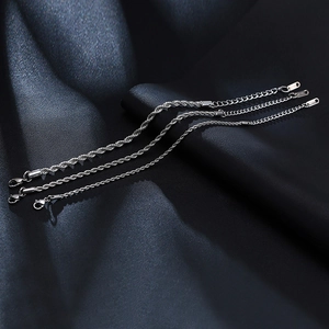 Detailaufnahme von 316L Edelstahl-Kordelketten mit Karabinerverschluss auf blauer Seide