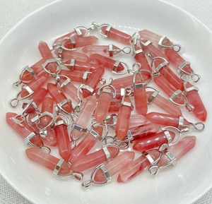 Macro shot of natural pink strawberry quartz hexagonal point pendants with silver bail