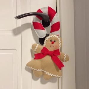 Gingerbread man door hanger decoration with plush candy cane and red bow detail
