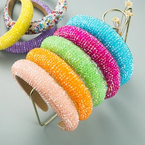 Fashion colorful crystal beaded sponge headbands displayed on a gold metal stand