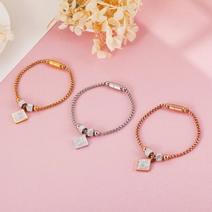 Bracelets magnétiques tricolores en or, argent et or rose sur fond rose texturé