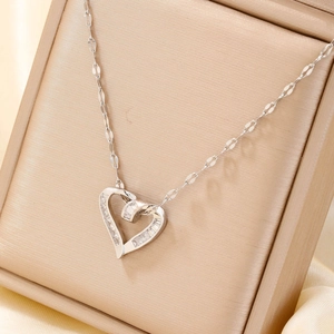Detail view of heart pendant necklace with clear cubic zirconia on satin jewelry box
