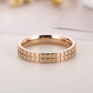 Macro shot of rose gold stainless steel ring featuring dual-row checkered geometric texture