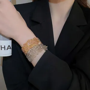 Minimalist butterfly cutout bangle in gold and silver finish on a female model