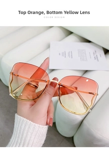 Detailed shot of rimless oversized sunglasses with orange to yellow gradient lenses