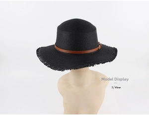 Detail of black straw boater hat with a brown leather belt and golden buckle trim