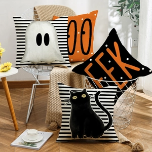 Set of four Halloween linen pillow covers with ghost, black cat and stripes on a white chair