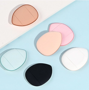 Flat lay of six colorful droplet-shaped mini finger powder puffs on a bicolor background