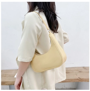 Pale yellow hobo shoulder bag shown on a model against a minimalist studio background