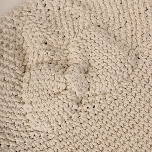 Détail macro de la texture en coton tricoté main crème de qualité sur ce chapeau