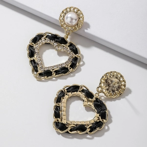 Vue détaillée des boucles d'oreilles cœur avec similicuir tressé, strass et perles