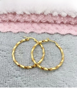 Detailed view of 18K gold plated stainless steel twisted hoop earrings with secure click closure