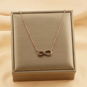 Macro view of rose gold infinity necklace with small diamonds on jewelry box lid