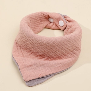 Detail of a dual-sided pink and grey cotton gauze baby bib with secure white snap buttons