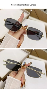 Macro detail of golden metal rectangle sunglasses featuring dark grey lenses
