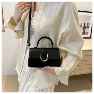 Close-up of black PU leather handbag featuring a prominent gold D-ring metal buckle detail