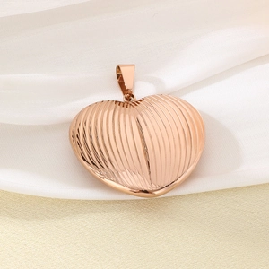 Close-up of rose gold heart pendant with vertical stripes on elegant white silk fabric