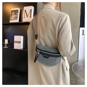 Close-up of black rhinestone waist bag with stylish herringbone patterned wide strap
