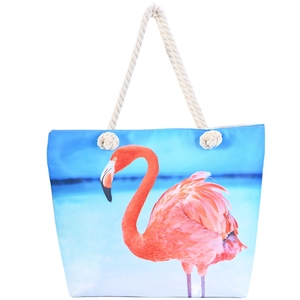 Macro shot of blue canvas beach tote with pink flamingo prints and thick rope handles