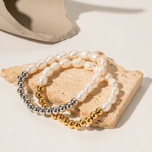 Vue détaillée de bracelets en perles or et argent sur une surface en pierre naturelle