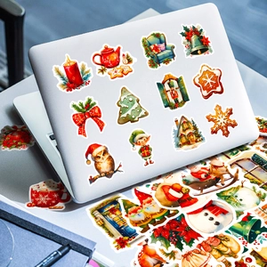 Various Christmas stickers including trees and snowmen decorating a laptop lid
