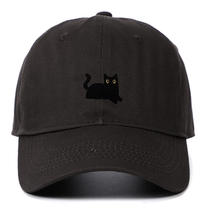 Détail d'une casquette en coton noir avec broderie chat noir aux yeux jaunes nets