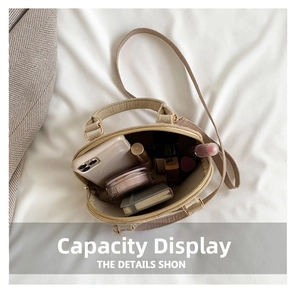 Interior view of beige shell bag showing phone, lipstick and powder for capacity