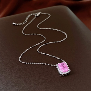 Close-up of silver necklace with pink rectangular crystal pendant and adjustable chain