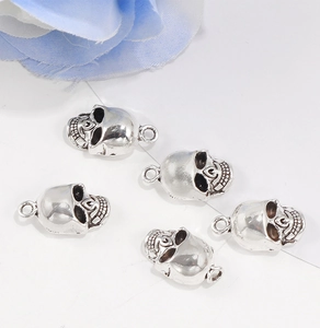 Detailed view of silver skull pendants with metal rings for jewelry making