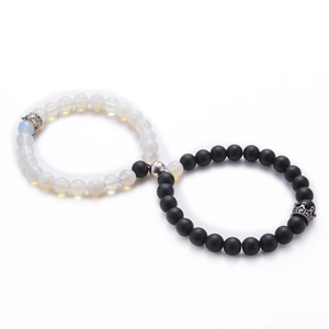 Macro view of 8mm white opal and black lava stone couple bracelets with magnetic crowns