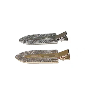 Pair of gold and silver metal hair clips with rhinestones in an elegant oval duckbill design