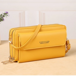 Detailed view of yellow faux leather crossbody phone bag with triple zippers and gold hardware