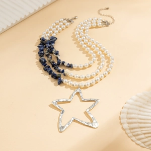 Detail view of multi-layer pearl and turquoise necklace with oversized star pendant