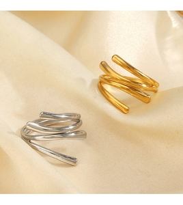 Detail of 18K gold and silver layered spiral rings on elegant champagne silk fabric