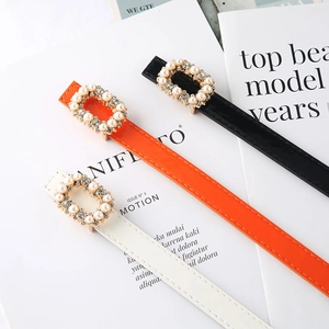 Three thin fashion belts for women in black, orange, and white with pearl buckle