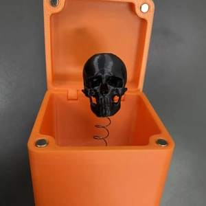 Vista macro di un teschio stampato in 3D in una scatola regalo a sorpresa arancione