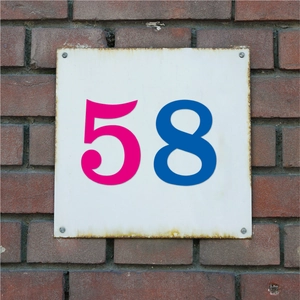 Gros plan d'autocollants numérotés 58 en vinyle imperméable sur un mur en briques rouges
