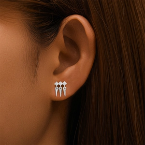 Détail d'un clou d'oreille en argent S925 avec trois zircons et pendentifs coniques