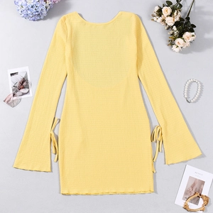 Détail de la robe jaune clair avec manches évasées et poignets à lacets stylés