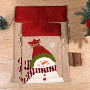 Christmas snowman drawstring gift bags in small and large sizes on wooden background