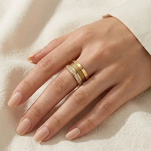 Stackable gold ring set featuring Roman numerals and cubic zirconia on a model's hand