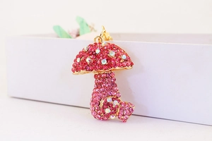 Close-up of pink crystal-encrusted mushroom charm with sparkling metal keychain details