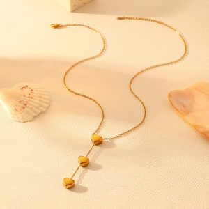Détail de la chaîne en acier inoxydable plaqué or 18k avec triple pendentifs cœur