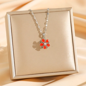 Titanium steel necklace with rotating red enamel flower pendant on a luxury gift box