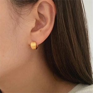 Detailed view of gold plated sterling silver hoop earrings with a textured wrinkled surface