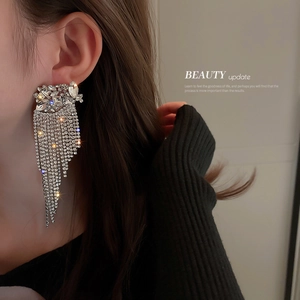 Luxury silver tassel flower earrings with rhinestones shown on a model