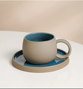 Dettaglio set tazza da caffè in ceramica con esterno grigio sabbia e interno blu intenso